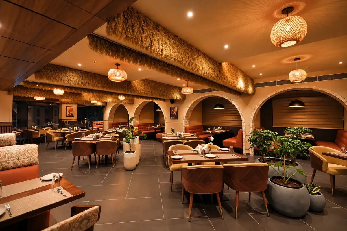 Intimate evening dining atmosphere under warm woven globes and leafy indoor planters